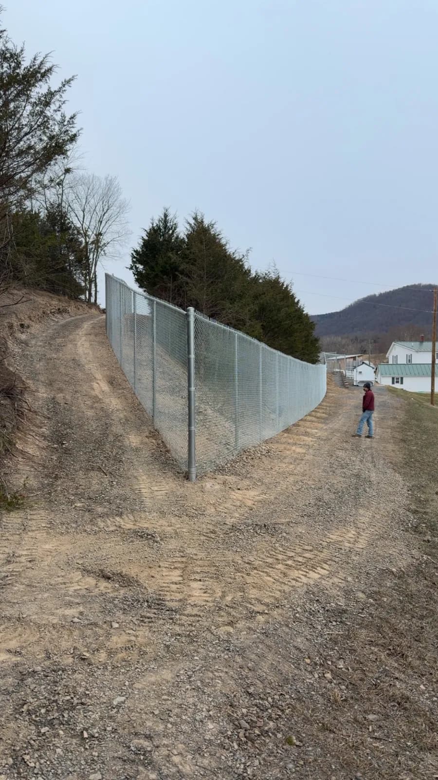Galvanized chain-link fence stepped down a graded slope