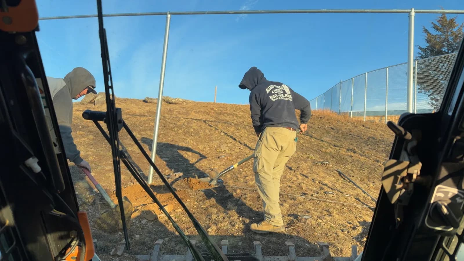Allied Fence & Decks crew pulling a string line on a chain-link fence install
