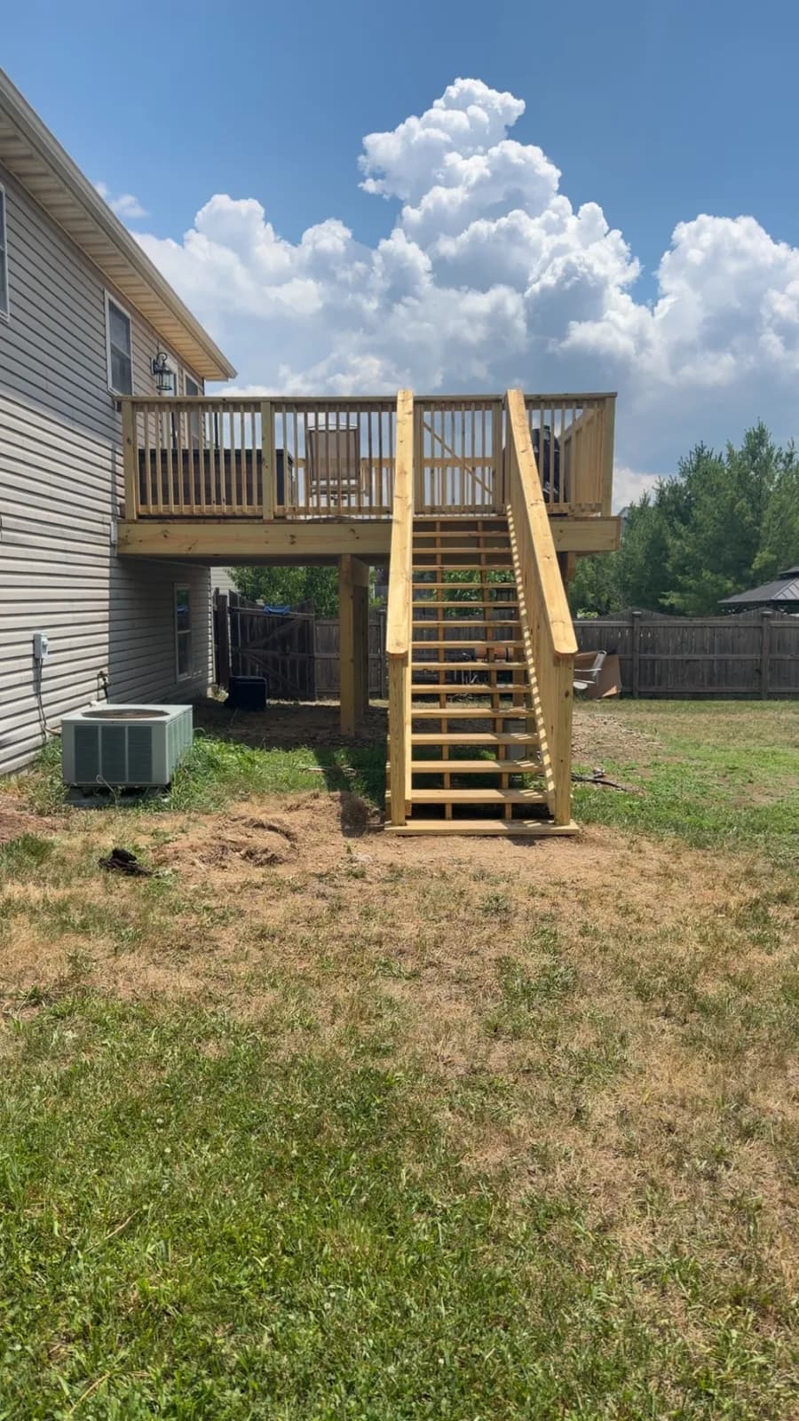 New pressure-treated elevated deck with railing and stairs