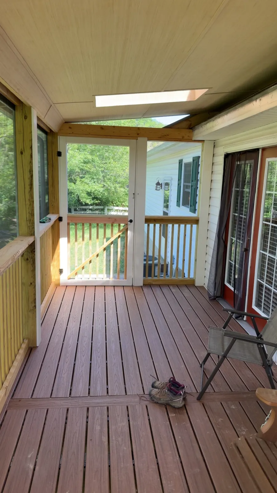 Screened porch interior with composite floor and screen door