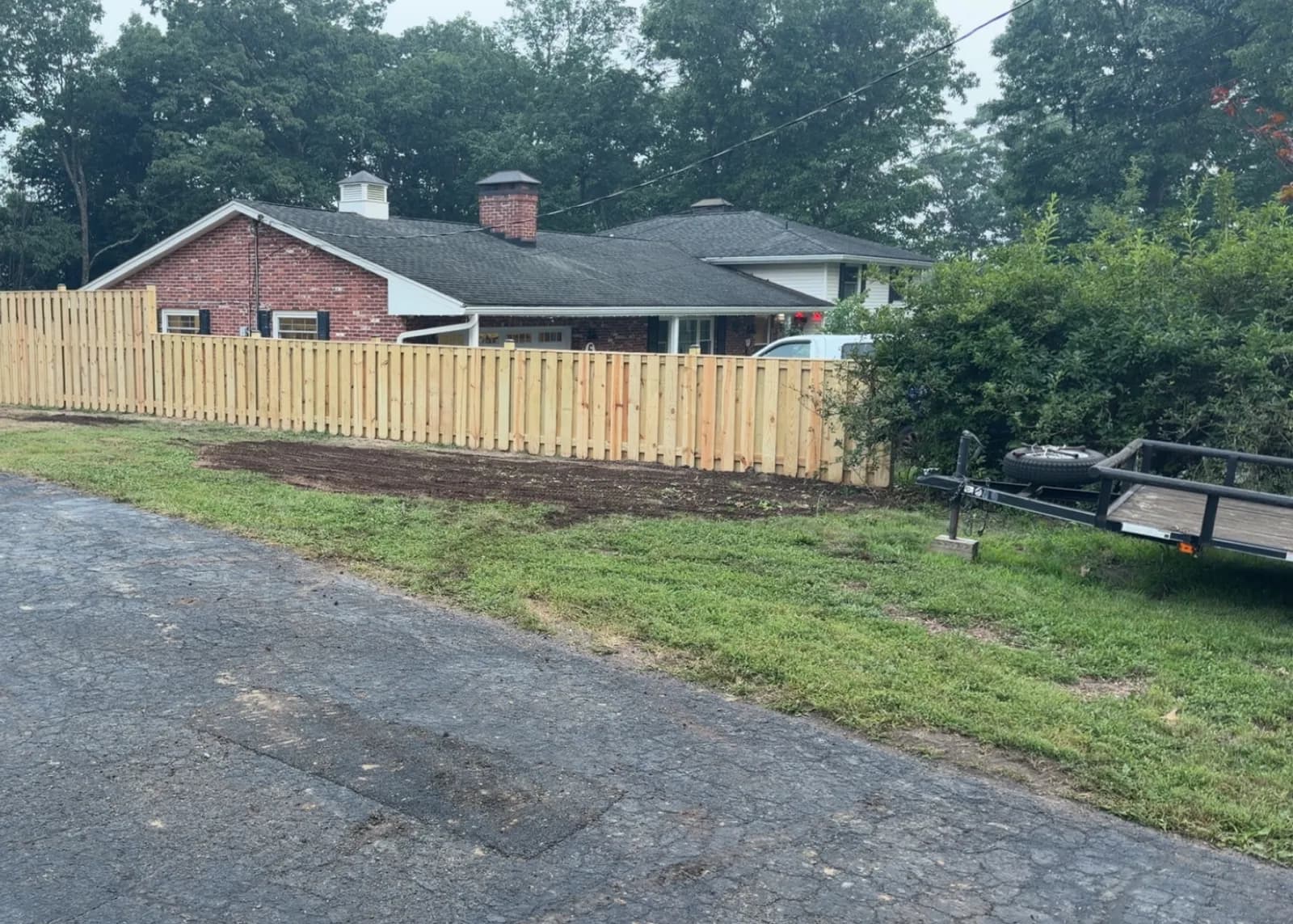 Long wood privacy fence along a brick home